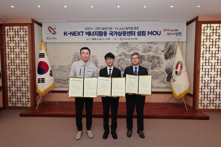[당진=뉴시스] 황침현(가운데) 당진시장 권한대행과 정외흠(오른쪽) 고등기술연구원 부사장, 장승호 와이케이 스틸(YK steel) 대표이사가 지난 22일 당진시청 해나루홀에서 K-NEXT 에너지활용 국가실증센터가 설립 업무협약을 맺은 뒤 협약서를 들고 기념 사진을 찍고 있다. (사진=당진=뉴시스) 2026.05.26. spark@newsis.com *재판매 및 DB 금지