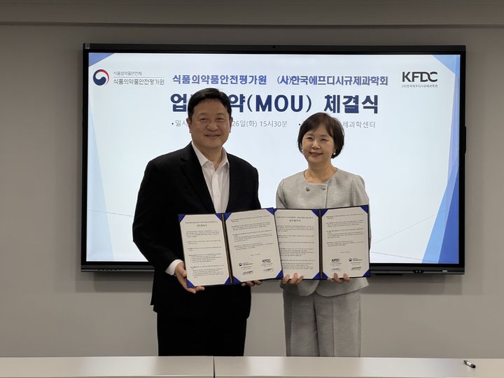 [서울=뉴시스] 강석연 식품의약품안전평가원장(왼쪽)과 이의경 KFDC규제과학회장이 26일 MOU를 체결하고 기념 촬영을 하고 있다. (사진=식약처 제공) 2026.05.26. photo@newsis.com *재판매 및 DB 금지