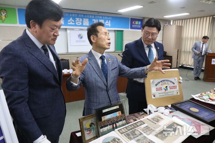 [전주=뉴시스] 아시안게임 3연패의 주인공인 박종길 전 차관이 27일 전북특별자치도체육회에서 정강선 전북체육회장과 문승우 체육역사기념관 TF위원장에게 소장품을 설명하고 있다. 2026.05.27   *재판매 및 DB 금지