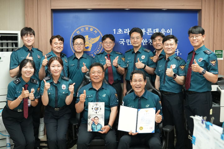 [예산=뉴시스] 충남경찰청 제1호 폴-브릿지 수상자로 선정된 신인철(얼굴 시계) 경감이 27일 논산경찰서에서 동료들과 기념 사진을 찍고 있다. (사진=충남경찰청 제공) 2026.05.27. photo@newsis.com *재판매 및 DB 금지