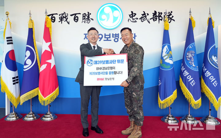 [창원=뉴시스]BNK경남은행 최진권(왼쪽) 상무가 지난 26일 오후 제39보병사단 김정도 사단장에게 국군장병 위문금을 전달하고 있다.(사진=BNK경남은행 제공) 2026.05.27. photo@newsis.com