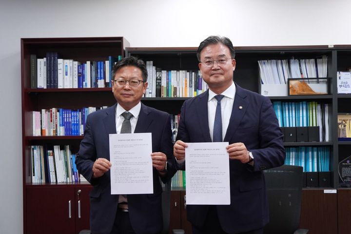 [서울=뉴시스]더불어민주당과 진보당이 6·3 지방선거 울산시장 단일화와 관련 역선택방지 조항이 포함된 여론조사 경선에 27일 합의했다. 사진은 합의문을 들고 있는 신창현 진보당 사무총장(왼쪽)과 이연희 더불어민주당 전략기획위원장(오른쪽) (사진=더불어민주당 제공) 2026.05.27. photo@newsis.com *재판매 및 DB 금지