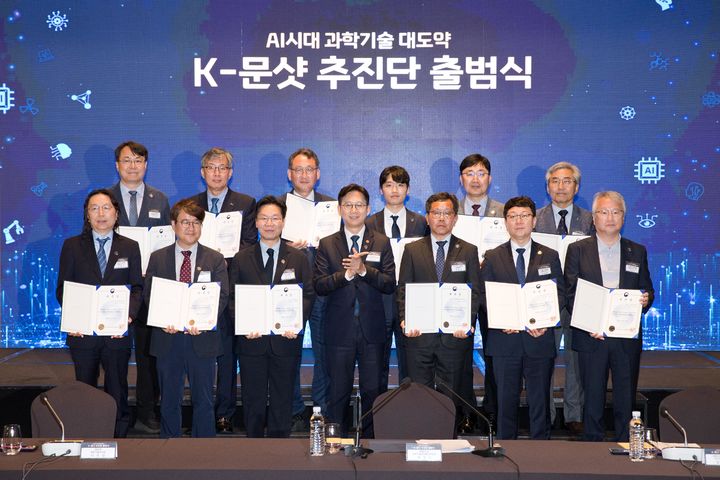[서울=뉴시스] 배경훈 부총리 겸 과학기술정보통신부 장관이 지난달 27일 오후 서울 용산구 드래곤시티호텔에서 열린 'K-문샷 추진단 출범식' 에서 총괄관리자(PD)들과 기념촬영을 하고 있다. 사진 왼쪽 뒤에서 네번째가 AI과학자 미션 PD를 맡았던 이민형 아스테로모프 대표. (사진=과학기술정보통신부 제공) 2026.05.27. photo@newsis.com *재판매 및 DB 금지