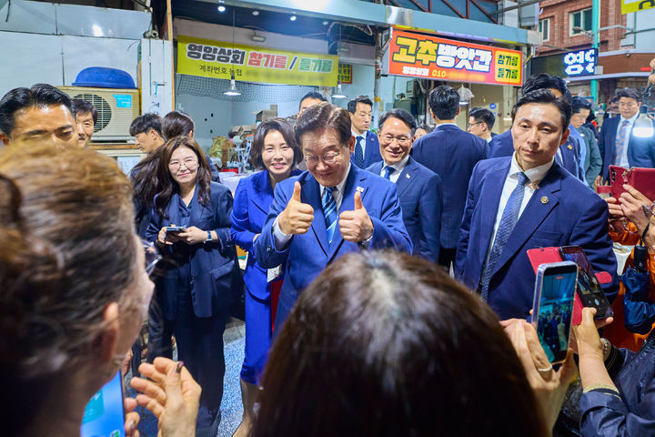 [서울=뉴시스] 최동준 기자 = 이재명 대통령과 김혜경 여사가 27일 부산 영도구 남항시장을 방문해 시민들과 인사하고 있다. (사진=청와대 제공) 2026.05.27. photo@newsis.com *재판매 및 DB 금지