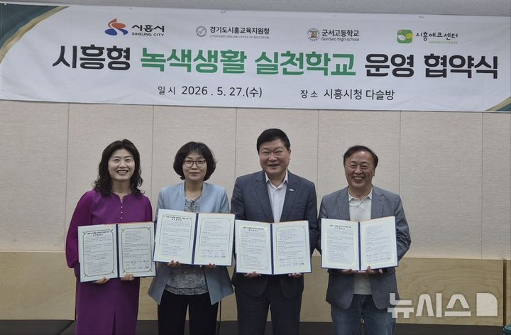 [시흥=뉴시스] '녹색생활 실천학교' 운영 협약식 참석들이 협약서에 서명한 후 기념 촬영을 하고 있다. (사진=시흥시 제공).2026.05.20.photo@newsis.com