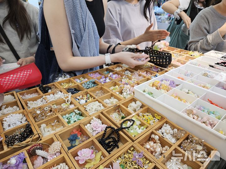 [서울=뉴시스]염지윤 인턴기자=젤리슈즈 위에 파츠를 올려보며 ‘신꾸’를 하고 있는 동대문종합시장 방문객들. 2026.05.27. photo@newsis.com