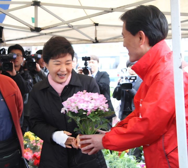 [춘천=뉴시스] 28일 국민의힘 김진태 강원특별자치도지사 후보가 이날 원주 중앙시장을 방문한 박근혜 전 대통령에게 꽃다발을 전하고 있다. 이에 박근혜 전대통령은 "김진태 지사 후보는 제가 오랫동안 알고 지내온 분으로 정말 책임감 있고 또 성실하게 일을 잘 하시는 분으로 기억하고 있다"며 "앞으로 강원도가 계속 발전해 나가려면 우리 원주 시민 여러분 그리고 강원 도민 여러분이 부디 많은 도움을 주셨으면 한다"고 당부했다. 김진태 후보측 제공. *재판매 및 DB 금지