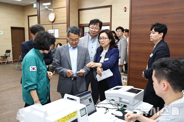 [창원=뉴시스] 박일웅(앞줄 왼쪽 두번째) 경남도지사 권한대행이 28일 창원특례시 성산구 중앙동 행정복지센터 사전투표소를 방문해 준비 상황을 점검하고 있다. (사진=경남도 제공) 2026.05.28. photo@newsis.com