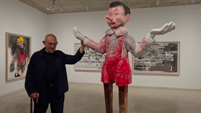 [사진=박현주 미술전문기자] 미국 현대미술 거장 짐 다인(Jim Dine)이 서울 종로구 피비갤러리 전시장에서 12년 전 제작한 대형 목조 피노키오 조각의 팔을 붙잡은 채 활짝 웃고 있다. 2026.05.28. hyun@newsis.com *재판매 및 DB 금지