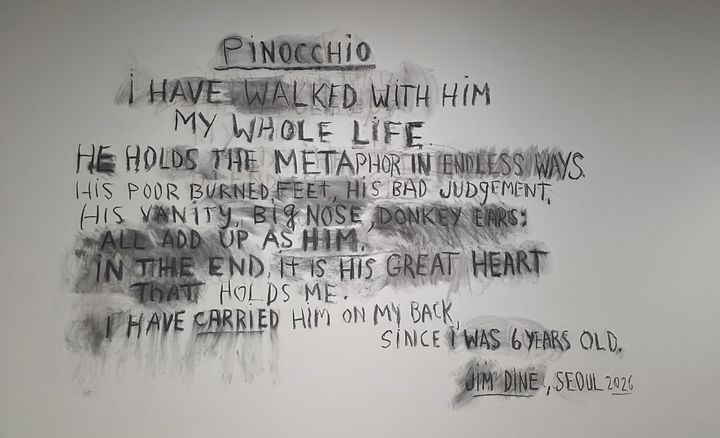 [사진=박현주 미술전문기자]짐 다인이 서울 피비갤러리 전시장 벽면에 직접 남긴 wall drawing. “나는 평생 피노키오와 함께 걸어왔다(I have walked with him my whole life)”라는 문장을 중심으로, 피노키오를 인간의 결핍과 고통, 성장의 은유로 풀어낸 작가의 선언적 문장이 펼쳐진다. 짐 다인은 피노키오를 “끝내 인간이 되어가는 존재”이자 자신의 또 다른 자화상이라고 설명했다. 2026.05.28. *재판매 및 DB 금지