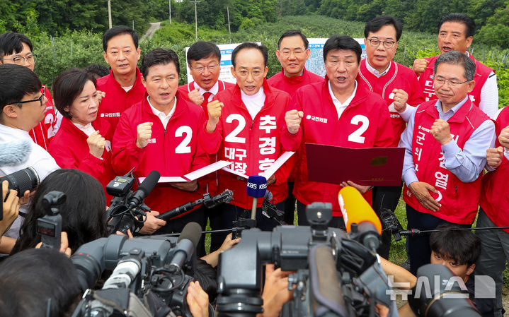 [대구=뉴시스] 이무열 기자 = 추경호(가운데) 국민의힘 대구시장 후보가 28일 오전 대구 군위군 소보면 내의리 대구경북통합신공항 건설 예정지를 찾아 신공항특별법 개정 당론 채택 결의문을 낭독하고 있다. 2026.05.28. lmy@newsis.com