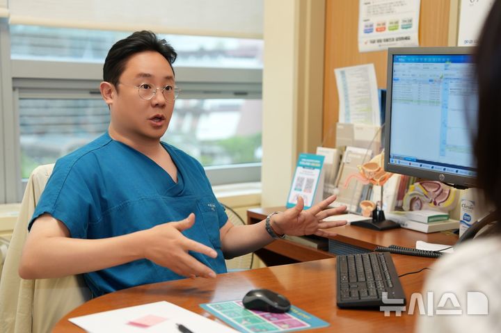 [서울=뉴시스] 다빈치 SP 단일공 로봇을 활용한 후복막 접근 요추 교감신경절제술로 국내 처음으로 발 다한증 치료에 성공한 방석환 서울성모병원 비뇨의학과 교수가 27일 수술 후 첫 외래에서 환자의 수술 후 경과를 확인하고 있다. (사진= 서울성모병원 제공) 