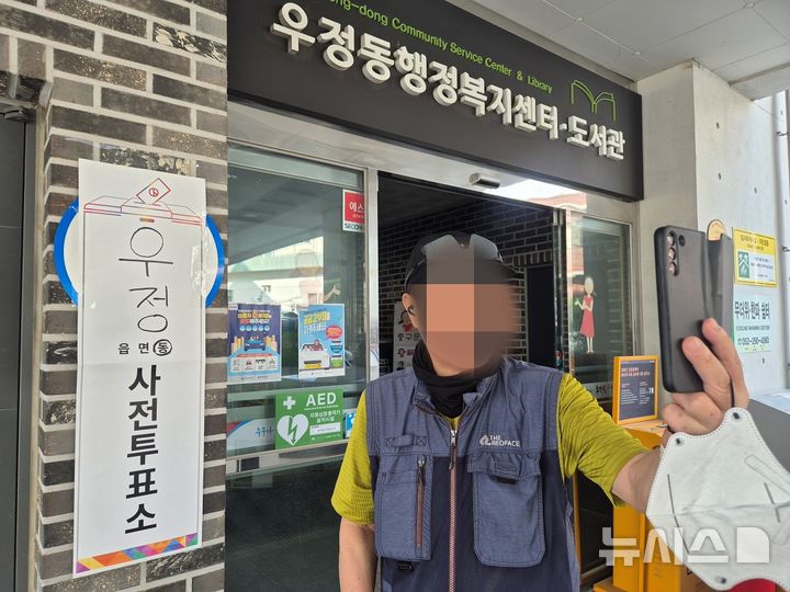 [울산=뉴시스] 구미현 기자 = 29일 6·3 지방선거 사전투표 첫날 오전 울산 중구 우정행정복지센터 사전투표소를 찾은 한 시민이 투표소를 배경으로 인증 사진을 찍고 있다. 2026.05.29. gorgeouskoo@newsis.com