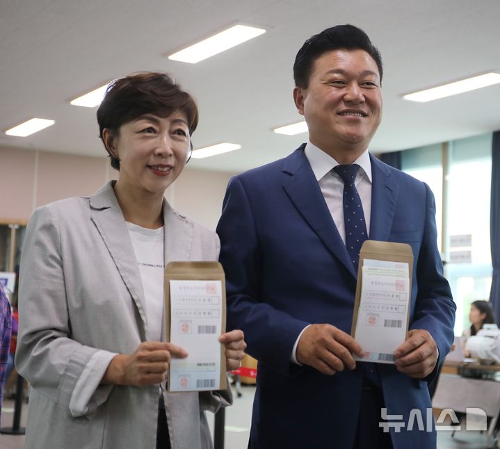 [보은=뉴시스] 서주영 기자 = 제9회 전국동시지방선거 사전투표 첫 날인 29일 오전 충북 보은군 보은읍행정복지센터에 마련된 사전투표소에서 신용한 더불어민주당 충북지사 후보와 배우자 이채영씨가 투표지를 들고 사진 촬영을 하고 있다. 2026.05.29. juyeong@newsis.com