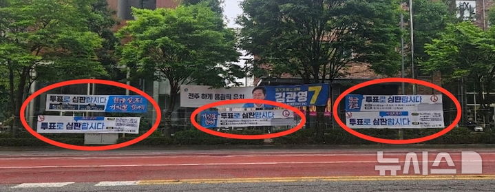 [전주=뉴시스] 김얼 기자 = 전북 곳곳에 걸린 김관영(무소속) 전북특별자치도지사 후보의 선거 현수막 인근에 더불어민주당 전북특별자치도당에서 내건 현수막이 걸려있다. 이 빨간 동그라미에 있는 현수막에는 '현금 살포! 거짓말 정치! 투표로 심판합시다'라는 문구와 함께 사전 투표와 본투표 안내가 적혀 있어 사실상 김관영 전북특별자치도지사 후보를 겨냥한 것처럼 보인다는 여론이다. 2026.05.29. pmkeul@newsis.com