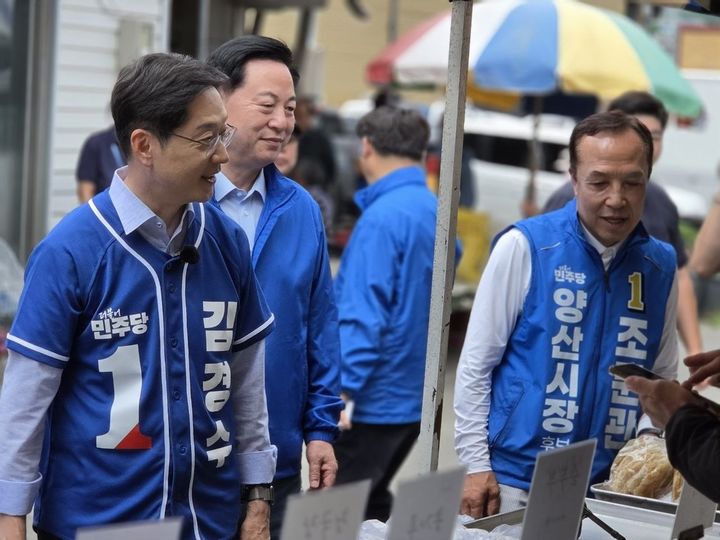 [양산=뉴시스] 더불어민주당 김경수 경남도지사 후보와 조문관 양산시장 후보, 김두관 전 의원이 양산 서창시장을 찾아 상인·주부들과 직접 소통하며 지지를 호소하고 있다. (사진=조문관 선거사무소 제공) 2026.05.29. photo@newsis.com *재판매 및 DB 금지