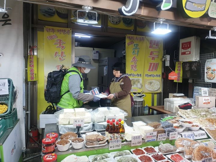 [서울=뉴시스]지난달 관악구 무단투기보안관이 인헌시장 상인에게 홍보물을 전달하고 있다. (사진=관악구 제공) 2026.05.29. photo@newsis.com *재판매 및 DB 금지