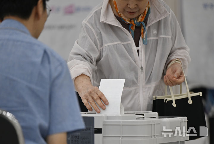[광주=뉴시스] 박기웅 기자 = 제9회 전국동시지방선거 사전투표 첫날인 29일 오전 광주 북구 전남대학교 컨벤션홀 용봉동사전투표소에서 유권자가 투표함에 투표용지를 넣고 있다. 2026.05.29. pboxer@newsis.com