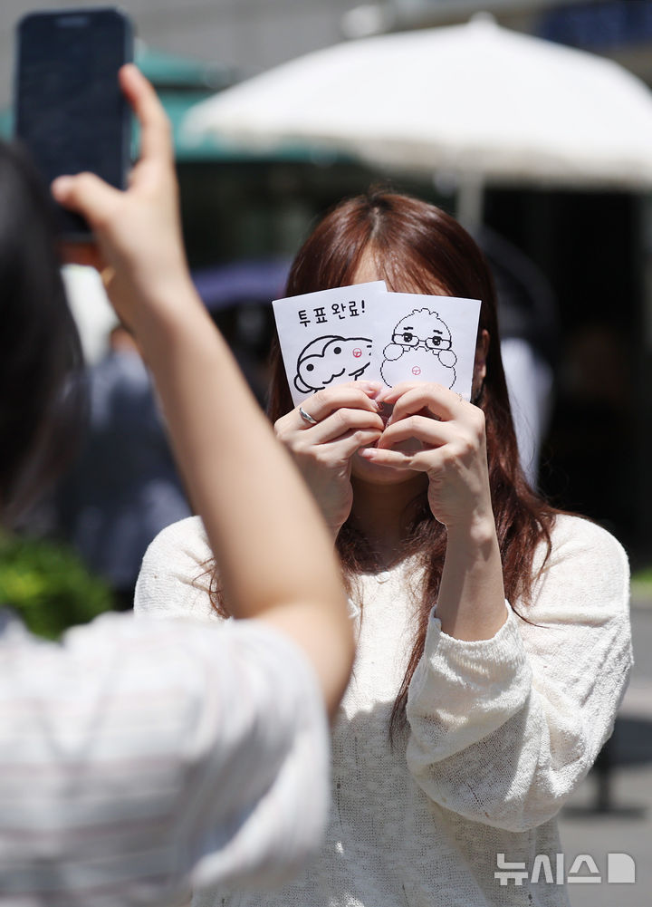 [서울=뉴시스] 김진아 기자 = 제9회 전국동시지방선거 사전투표 첫 날인 29일 서울 강남구 역삼1동 주민센터에 마련된 사전투표소에서 한 시민이 투표 완료 인증 사진을 찍고 있다. 2026.05.29. bluesoda@newsis.com