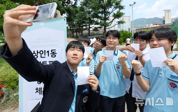 [대구=뉴시스] 이무열 기자 = 제9회 전국동시지방선거 사전투표 첫날인 29일 오후 대구 달서구 영남고등학교 체육관에 마련된 상인1동 사전투표소에서 투표를 마친 영남고 3학년 학생들이 투표확인증을 들고 인증사진을 찍고 있다. 2026.05.29. lmy@newsis.com