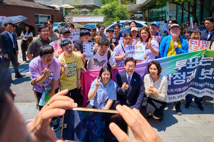 [서울=뉴시스] 최동준 기자 = 이재명 대통령과 김혜경 여사가 29일 서울 종로구 삼청동 주민센터 앞에서 발달장애인 참정권 보장 촉구 시민단체 의견을 청취한 뒤 함께 기념촬영하고 있다. (사진=청와대 제공) 2026.05.29. photo@newsis.com *재판매 및 DB 금지