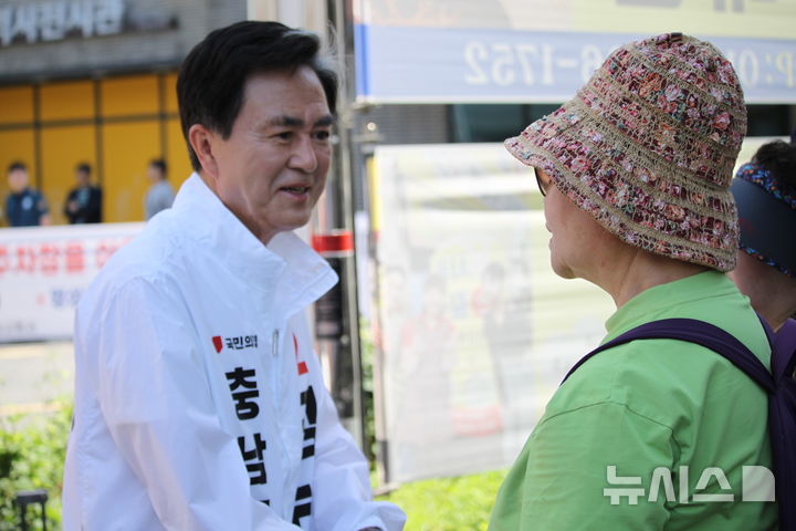[천안=뉴시스] 최영민 기자=김태흠 국민의힘 충남도지사 후보가 30일 충남 천안시 중앙동 천안중앙시장 앞에서 시민들과 만나 인사를 나누고 있다. 2026.05.30 ymchoi@newsis.com