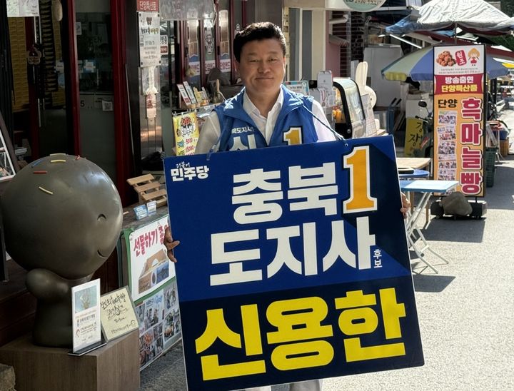 [청주=뉴시스] 더불어민주당 신용한 충북도지사 후보가 30일 단양 구경시장에서 피켓을 들고 거리 인사를 하고 있다. (사진=신용한 후보 선거대책위원회 제공) 2026.05.30. photo@newsis.com *재판매 및 DB 금지