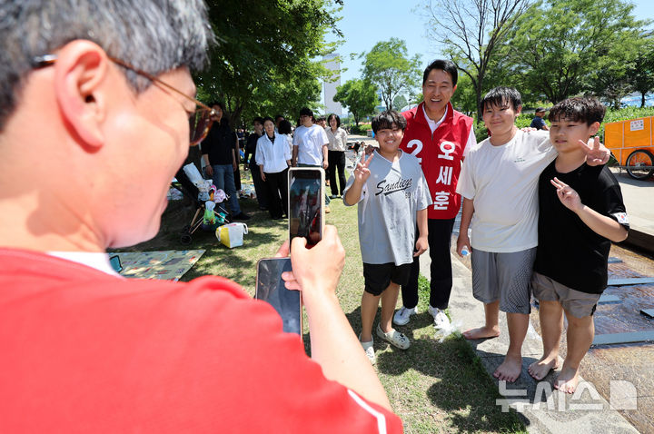 [서울=뉴시스] 이영환 기자 = 오세훈 국민의힘 서울시장 후보가 30일 오후 서울 영등포구 여의도한강공원을 찾아 어린이들과 기념촬영을 하고 있다. 2026.05.30. 20hwan@newsis.com