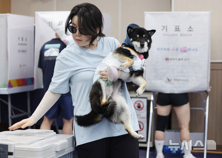[서울=뉴시스] 김진아 기자 = 제9회 전국동시지방선거 사전투표 마지막 날인 30일 서울 성동구 성수1가제2동 공공복합청사에 마련된 사전투표소에서 반려견을 안은 한 시민이 투표를 하고 있다. 2026.05.30. bluesoda@newsis.com