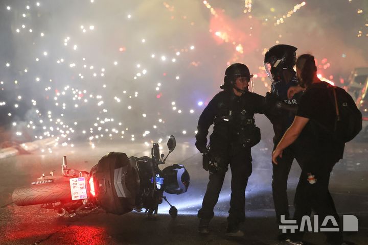 [파리=AP/뉴시스] 지난달 30일(현지 시간) 프랑스 파리에서 프로축구팀 파리 생제르맹(PSG)이 2025~2026 유럽축구연맹(UEFA) 챔피언스리그에서 우승하자 흥분한 팬들이 거리로 쏟아져 나와 폭력 사태가 발생한 가운데 경찰이 해산을 시키고 있다. 2026.06.01.