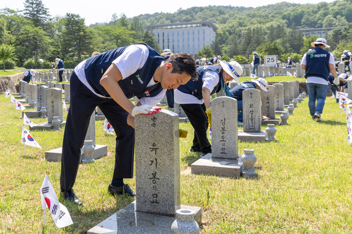 [서울=뉴시스] HD현대 정기선 회장이 지난 29일 국립서울현충원을 찾아 임직원들과 함께 참전용사의 비석을 닦고 있다.. (사진=HD현대 제공) photo@newsis.com *재판매 및 DB 금지