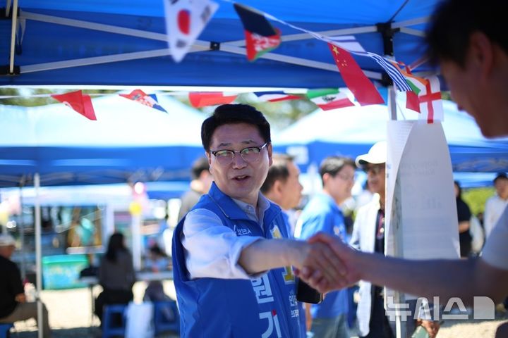 [의정부=뉴시스] 김원기 후보가 공설운동장 보조축구장에서 열린 몽골인 체육대회 먹거리 장터에서 한 상인과 악수를 하고 있다. (사진=김원기 캠프 제공) 2026.05.31 photo@newsis.com