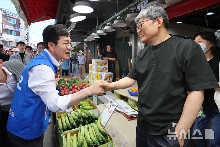 [서울=뉴시스] 권창회 기자 = 정원오 더불어민주당 서울시장 후보가 31일 서울 강동구 강동우체국 인근에서 열린 지역유세를 마친 뒤 길동 복조리 시장을 찾아 시장상인들과 인사하고 있다. 2026.05.31. kch0523@newsis.com