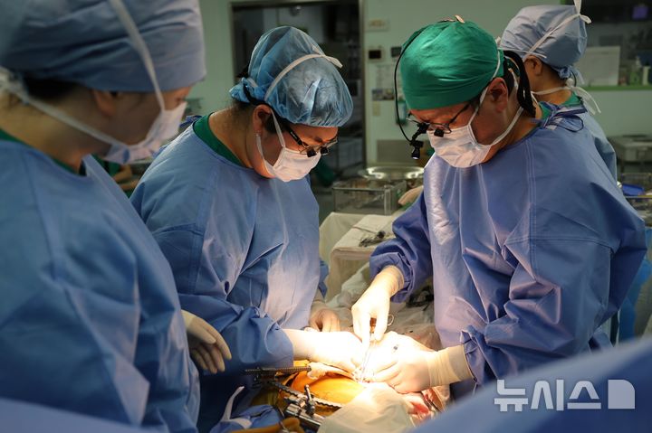 [서울=뉴시스] 서울아산병원 장기이식센터 신장이식팀이 지난달 20일 만성 신부전 환자에게 아내의 신장을 성공적으로 이식하며 신장이식 8000례를 달성했다. 오른쪽 첫 번째가 집도의인 김영훈 서울아산병원 신·췌장이식외과 교수, 두 번째가 권혜은 교수. (사진= 서울아산병원 제공)