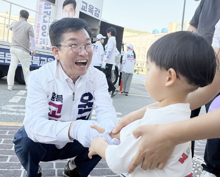 윤건영 충북교육감 후보가 1일 유세장에서 만난 어린이와 악수하며 반갑게 인사하고 있다.(사진=윤 후보 캠프 제공) *재판매 및 DB 금지