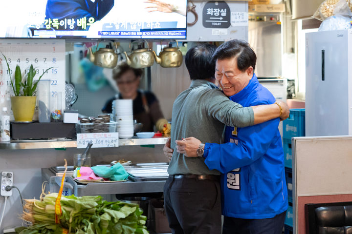 [광명=뉴시스] 박승원 더불어민주당 경기 광명시장 후보가 1일 시장에서 지역 소상공인을 끌어안고 있다. (사진=박승원 후보 선거사무소 제공) 2026.06.01. photo@newsis.com *재판매 및 DB 금지