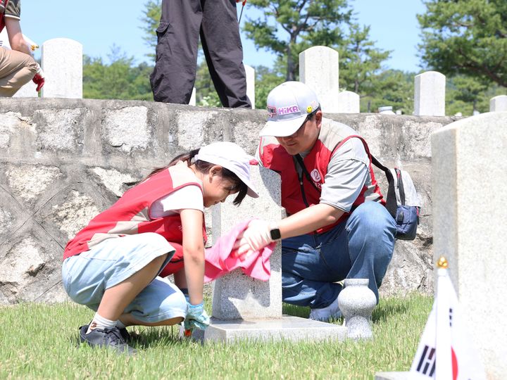 [서울=뉴시스] 롯데건설 ‘샤롯데 봉사단’이 지난달 30일 서울 동작구에 위치한 국립서울현충원 20번 묘역에서 비석을 닦고 태극기를 꽂는 등 봉사활동을 하고 있다. 2026.06.01. (사진=롯데건설 제공) photo@newsis.com *재판매 및 DB 금지