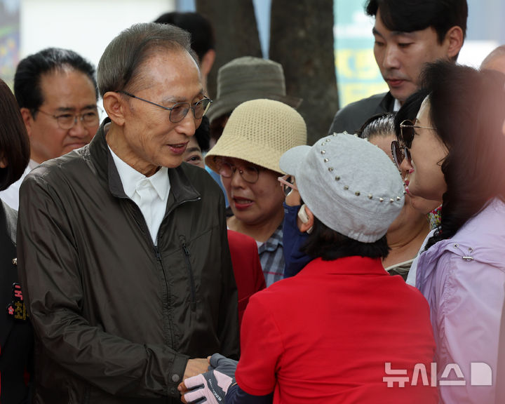 [서울=뉴시스] 배훈식 기자 = 이명박 전 대통령이 1일 오전 서울 성동구 서울숲에서 시민들과 악수하고 있다. 2026.06.01. dahora83@newsis.com