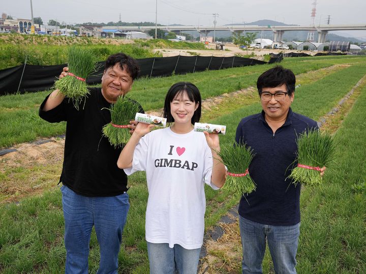 [서울=뉴시스] '김밥 큐레이터' 정다현 작가(가운데)와 영양부추 협력사 관계자들이 경기도 양주 영양 부추 농가에서 포즈를 취하고 있다. (사진=GS25 제공) 2026.06.02. photo@newsis.com *재판매 및 DB 금지