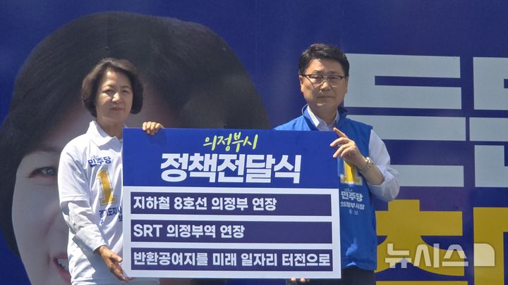 [의정부=뉴시스] 김원기 의정부시장 후보가 2일 행복로에서 추미애 경기지사 후보에게 의정부 핵심 현안이 담긴 정책을 전달하고 있다. (사진=김원기 후보 캠프 제공) 2026.06.02 photo@newsis.com