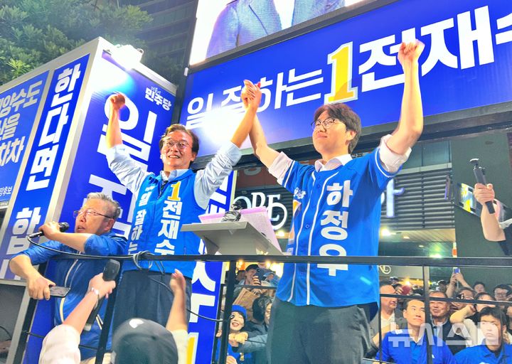 [부산=뉴시스] 원동화 기자 = 전재수 더불어민주당 부산시장 후보(왼쪽)와 하정우 부산 북구갑 국회의원 보궐선거 후보가 2일 부산 북구 뉴코아아울렛 앞에서 공동 피날레 유세에서 손을 맞잡고 지지들에게 인사를 하고 있다. 2026.06.02. dhwon@newsis.com
