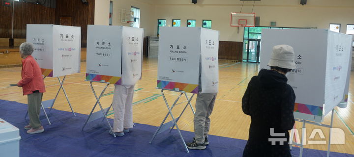 [전주=뉴시스] 김얼 기자 = 제9회 전국동시지방선거일인 3일 전북 전주시 완산구 중화산동 신흥중학교 체육관에 마련된 중화산1동 제2투표소에서 유권자들이 투표를 하기 위해 기표소로 들어서고 있다. 2026.06.03. pmkeul@newsis.com