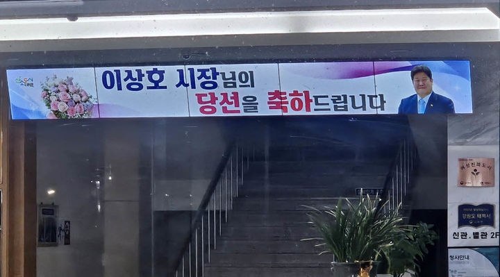 [태백=뉴시스]선거운동 마지막 날인 지난 2일 오후 태백시청 현관 로비에 '이상호 시장님의 당선을 축하드립니다'는 자막이 송출되고 있다.(사진=독자 제공) *재판매 및 DB 금지