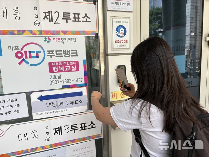[서울=뉴시스] 신유림 기자 = 제9회 전국동시지방선거일인 3일 낮 서울 마포구 대흥실뿌리복지센터 1층 강당에 마련된 대흥동 제3투표소에서 투표를 마친 김현아(20)씨가 투표 인증 사진을 찍고 있다. 2026.06.03. spicy@newsis.com