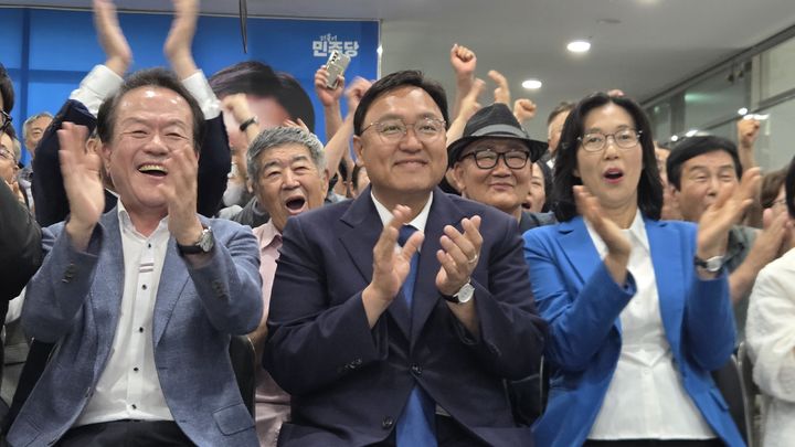 [세종=뉴시스] 송승화 기자 = 3일, KBS와 MBC, SBS 등 지상파 방송 3사의 제9회 전국동시지방선거 출구조사 결과에 박수치는 조상호(가운데) 더불어민주당 세종시장 후보. 2026.06.03. ssong1007@newsis.com. *재판매 및 DB 금지