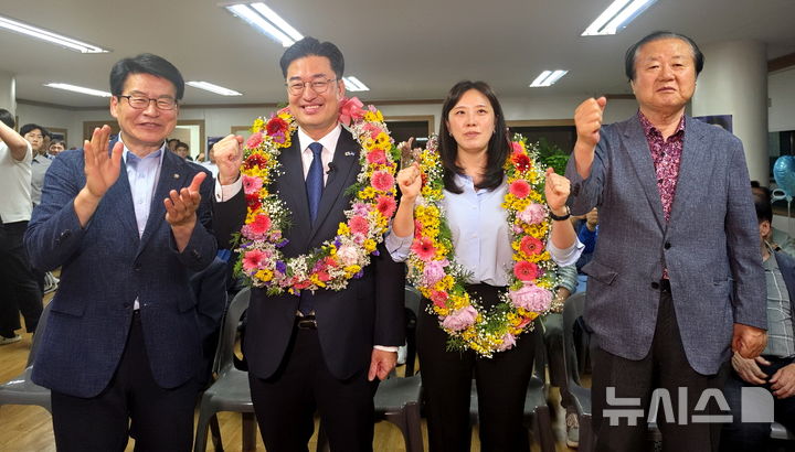 [진천=뉴시스] 김명식 더불어민주당 충북 진천군수 후보가 3일 자신의 선거사무소에서 배우자 정재윤(오른쪽 두 번째)씨와 임호선(왼쪽 첫 번째) 국회의원과 당선 기념촬영을 하고 있다. (사진=공동취재단) 2026.06.03. photo@newsis.com