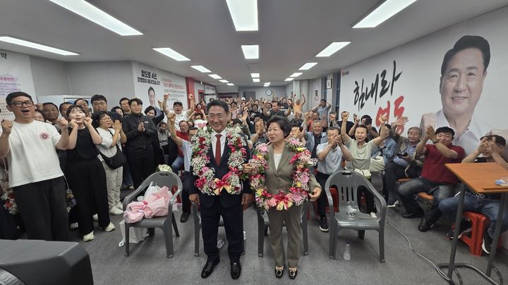 [영동=뉴시스] 국민의힘 정영철 충북 영동군수 후보가 3일 그의 선거사무소에서 부인과 함께 지지자들로부터 꽃다발을 받고 환호하고 있다. (사진=공동취재단) 2026.06.03. photo@newsis.com *재판매 및 DB 금지