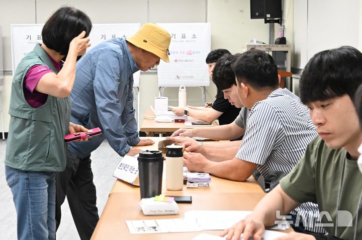 [광주=뉴시스] 이현행 기자 = 제9회 전국동시지방선거 본투표날인 3일 오전 광주 상무2동 제2투표소(쌍촌종합사회복지관)에서 유권자들이 본인확인을 거친 후 투표 용지를 받고 있다. 2026.06.03. lhh@newsis.com