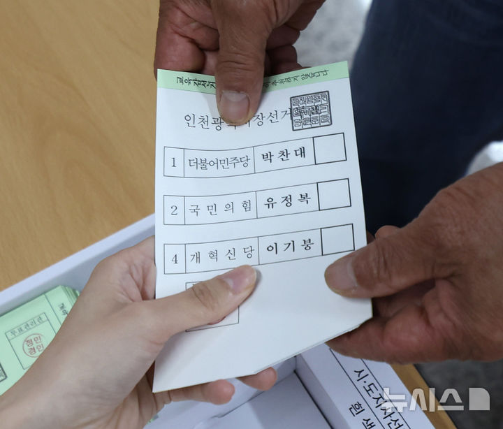 [인천=뉴시스] 전진환 기자 = 제9회 전국동시지방선거일인 3일 오전 인천 부평구보건소에 마련된 부평4동 제1투표소에서 한 유권자가 기표용지를 받고 있다. 2026.06.03. amin2@newsis.com
