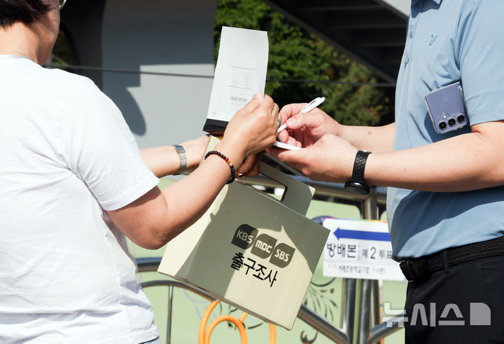 [서울=뉴시스] 최진석 기자 = 제9회 전국동시지방선거 선거일인 3일 서울 서초구 서래초등학교에 차려진 방배본동제2투표소에서 출구조사원들이 유권자들의 설문을 받고 있다. 2026.06.03. myjs@newsis.com